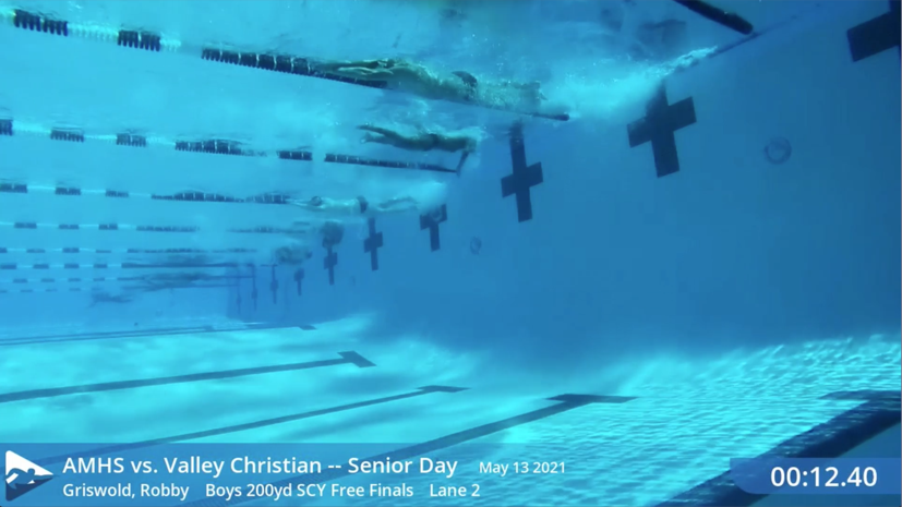 Underwater race frame with SwimClips broadcast graphics — meet name, swimmer, event, lane, and running time